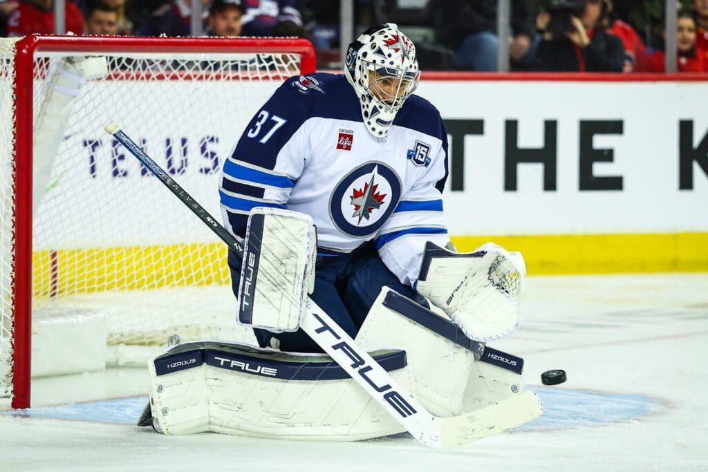 Nov 15, 2025; Calgary, Alberta, CAN; Winnipeg Jets goaltender Connor Hellebuyck (37) makes a save against the Calgary Flames during the second period at Scotiabank Saddledome. Mandatory Credit: Sergei Belski-Imagn Images