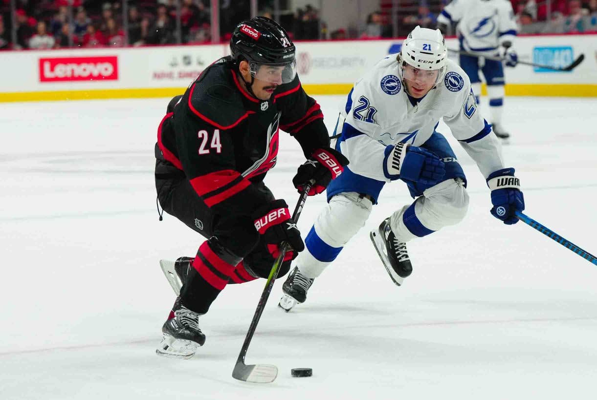 Carolina Hurricanes center Seth Jarvis (24) skates with the puck against Tampa Bay Lightning center Brayden Point (21) during the third period at PNC Arena.