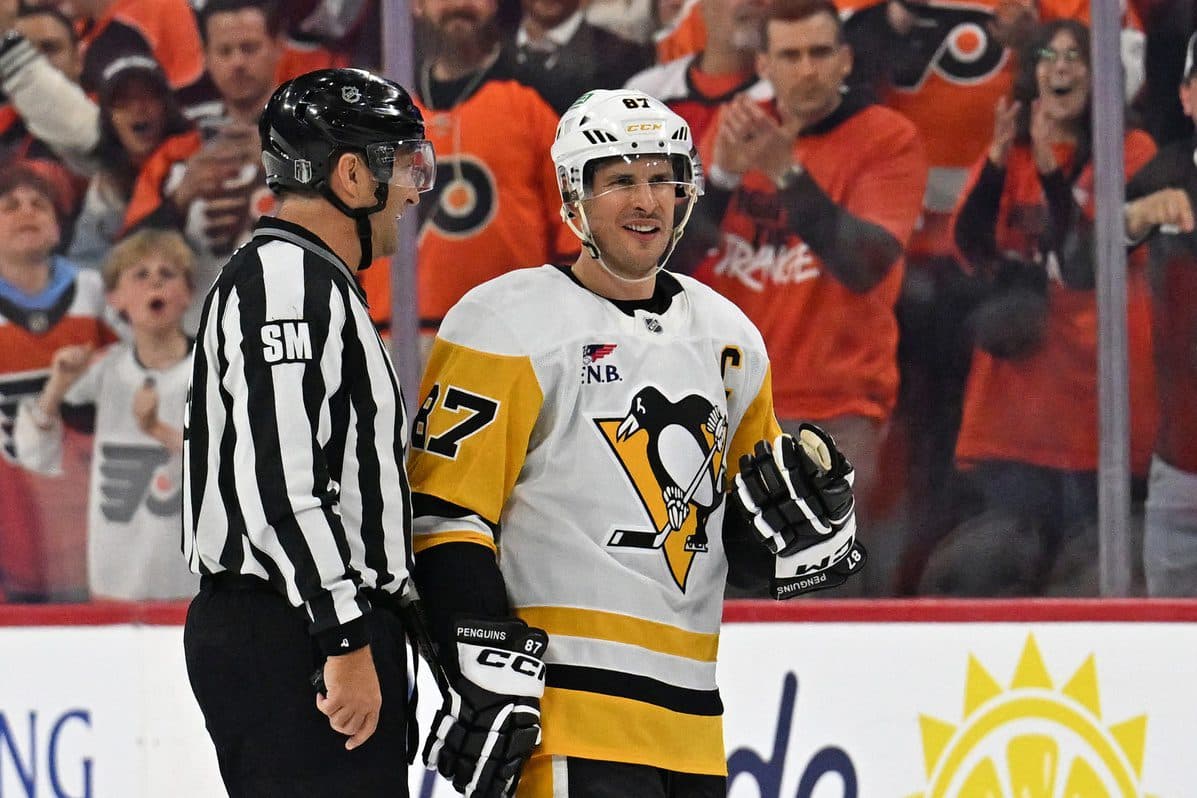 Pittsburgh Penguins center Sidney Crosby (87) is escorted to the penalty box by linesman Jonny Murray (95) against the Philadelphia Flyers during the second period in game three of the first round of the 2026 Stanley Cup Playoffs at Xfinity Mobile Arena.