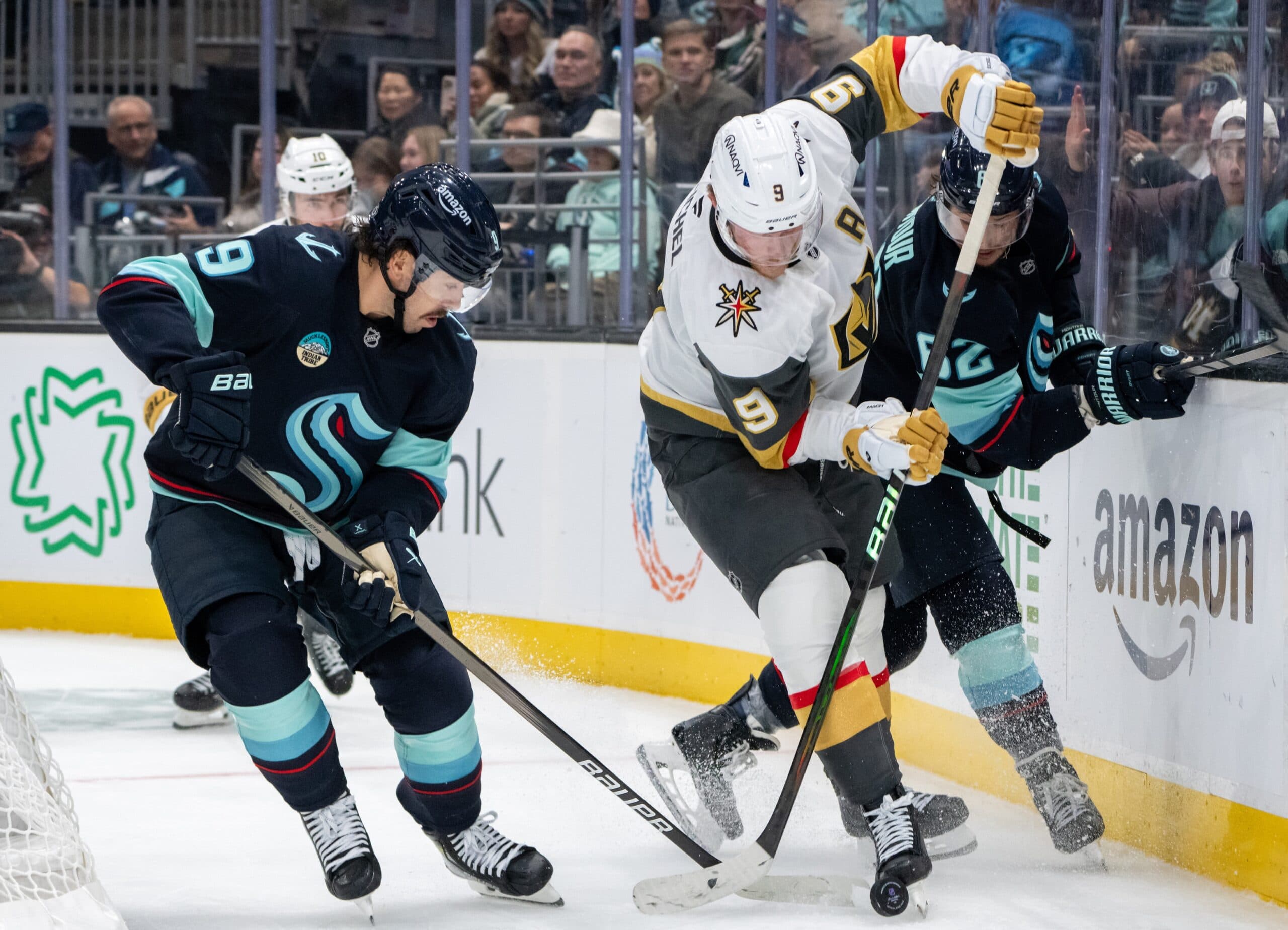 Vegas Golden Knights forward JackEichel (9) battles Seattle Kraken forward ChandlerStephenson (9) and defenseman BrandonMontour (62) for the puck during the third period at Climate Pledge Arena.