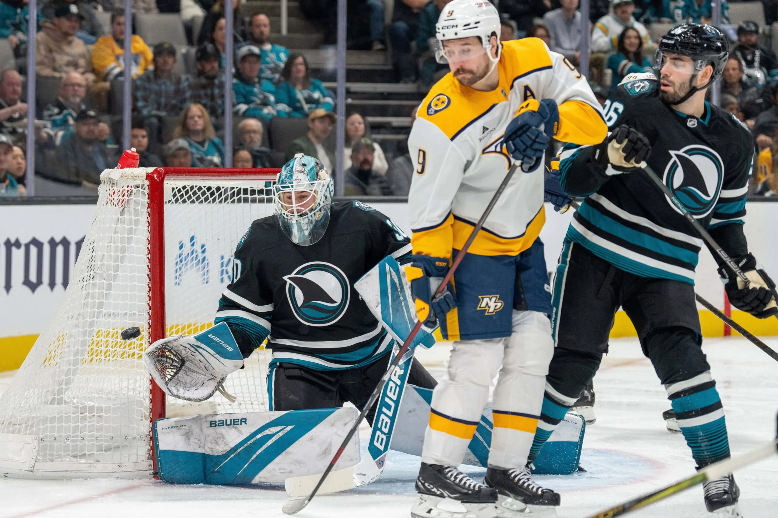 San Jose Sharks goaltender Yaroslav Askarov (30) makes a save with Nashville Predators left wing Filip Forsberg (9) fights for position during the first period at SAP Center at San Jose