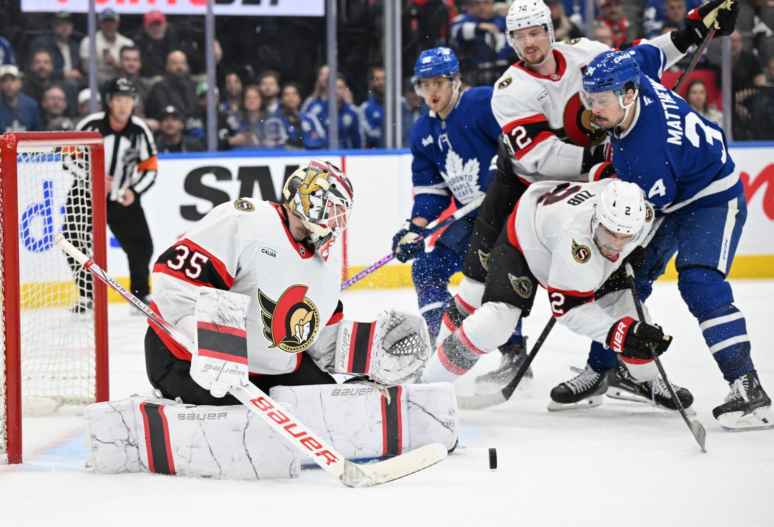 Ottawa Senators goalie Linus Ullmark (35) makes a save as defensemen Artem Zub (2) and Thomas Chabot (72) hold back Toronto Maple Leafs forward Auston Matthews (34) in the third period at Scotiabank Arena.