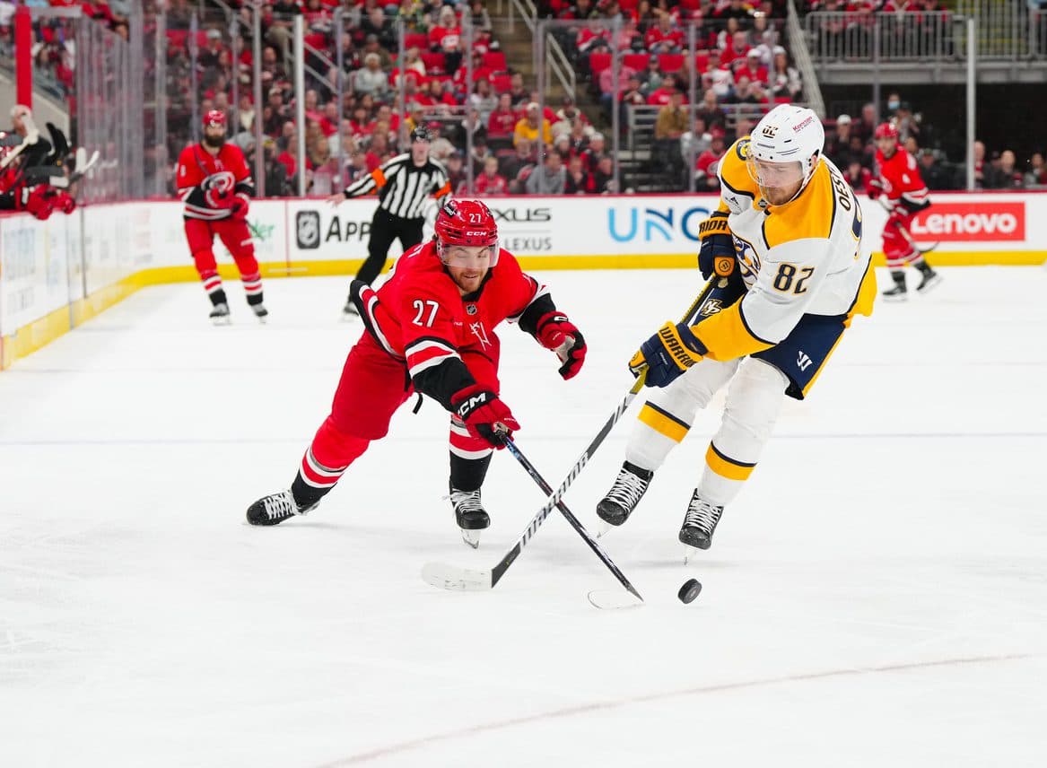 Nashville Predators defenseman Jordan Oesterle (82) and Carolina Hurricanes center Tyson Jost (27) battle over the puck during the third period at Lenovo Center.