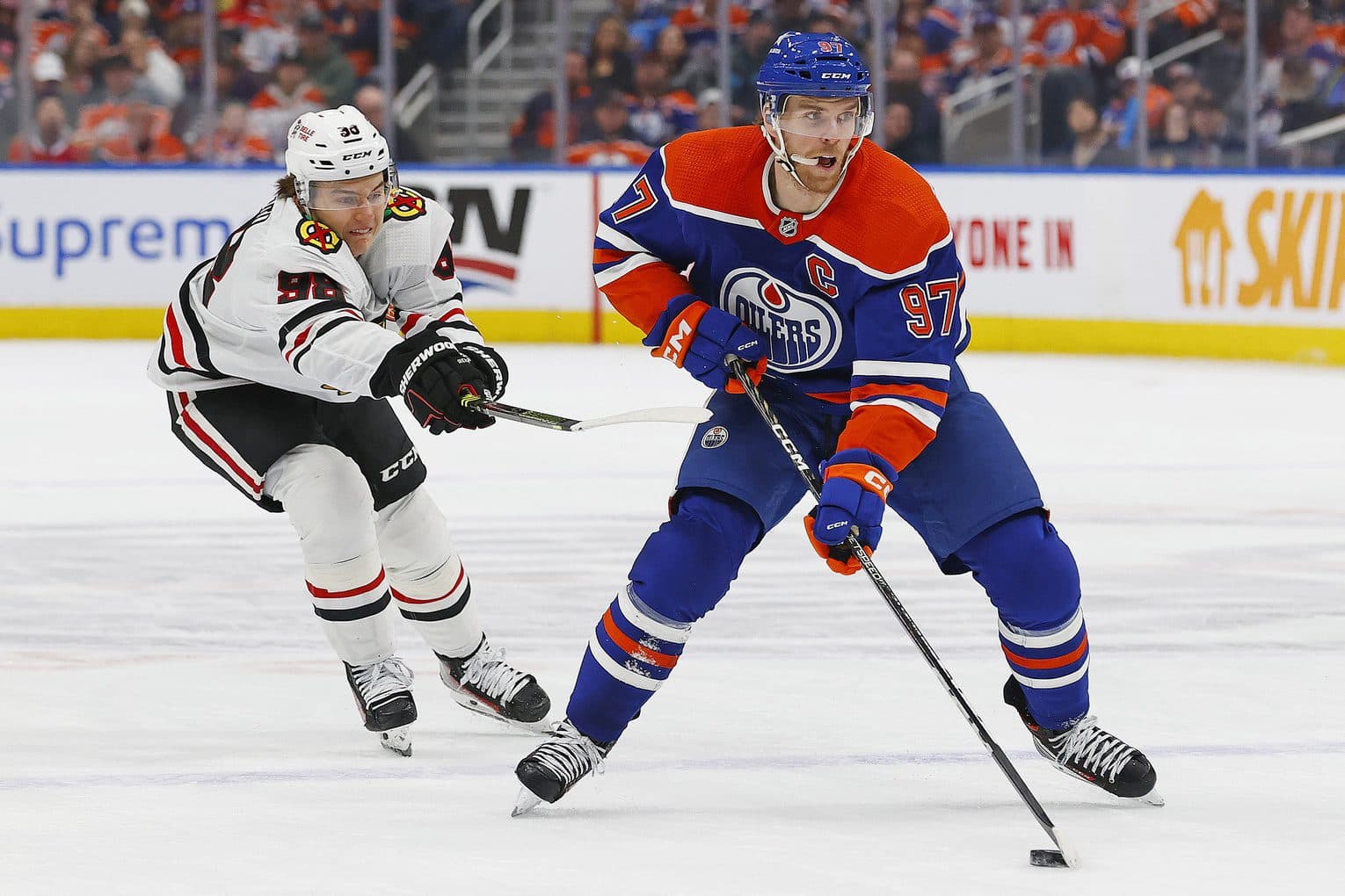 Chicago Blackhawks forward Connor Bedard (98) tries to knock the puck away from Edmonton Oilers forward Connor McDavid (97) during the first period at Rogers Place.