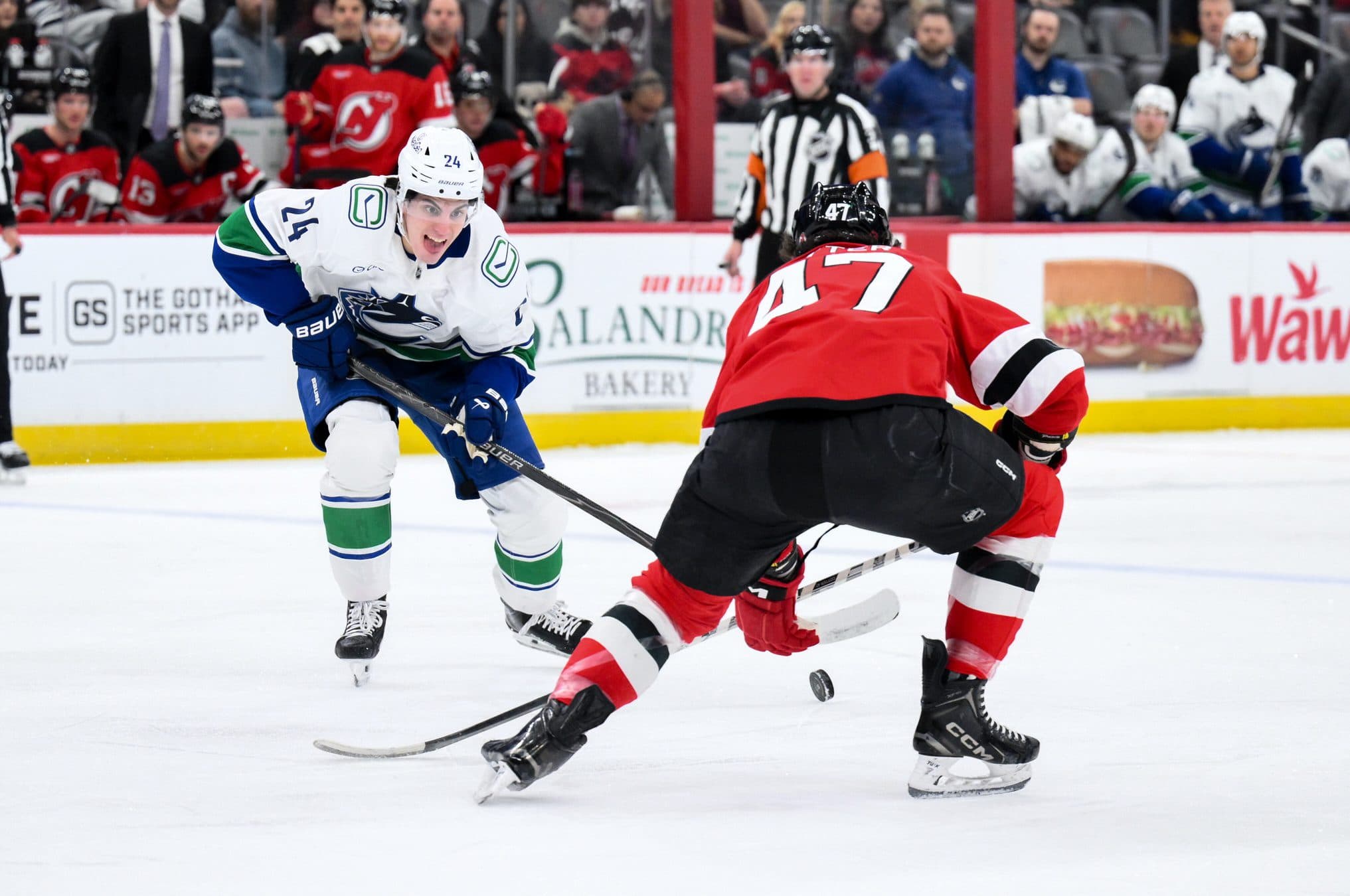 Vancouver Canucks defenseman Zeev Buium (24) skates with the puck while defended by New Jersey Devils left wing Paul Cotter (47) during the first period at Prudential Center.