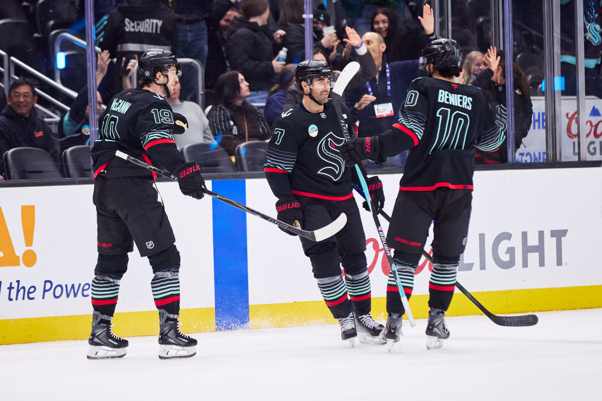 Seattle Kraken right wing Jordan Eberle (7) celebrates with Seattle Kraken center Matty Beniers (10) and Seattle Kraken left wing Jared McCann (19) after scoring an empty net goal during the third period against the New Jersey Devils at Climate Pledge Arena.