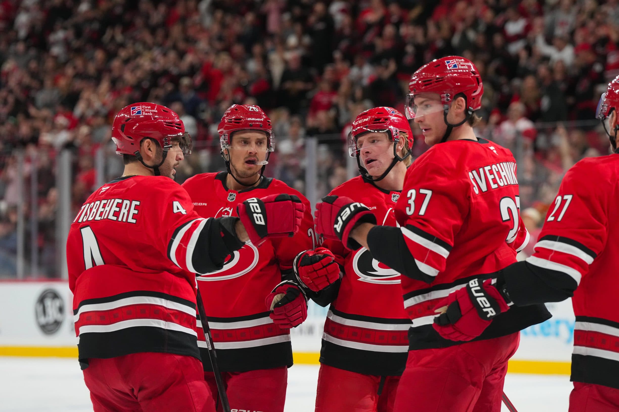 Carolina Hurricanes right wing Andrei Svechnikov (37) celebrates his goal with right wing Jackson Blake (53) center Sebastian Aho (20) and defenseman Shayne Gostisbehere (4) against the Vancouver Canucks during the first period at Lenovo Center.